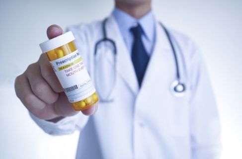 Medication assisted treatment - doctor holding pill bottle