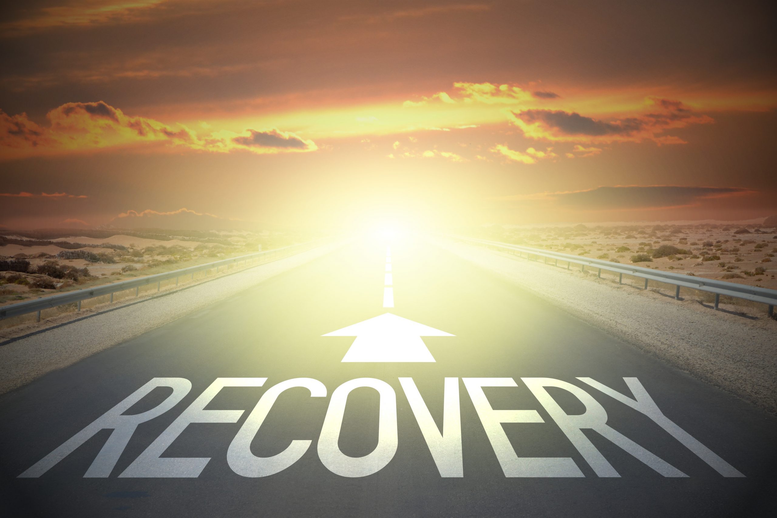 road towards sunset with traffic arrow reading recover - Long-Term Treatment for Addiction concept image